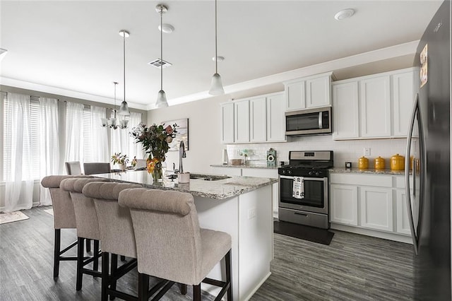5681 Oakworth St, Slidell, LA 70461 - kitchen featuring appliances with stainless steel finishes, backsplash, and a breakfast bar area