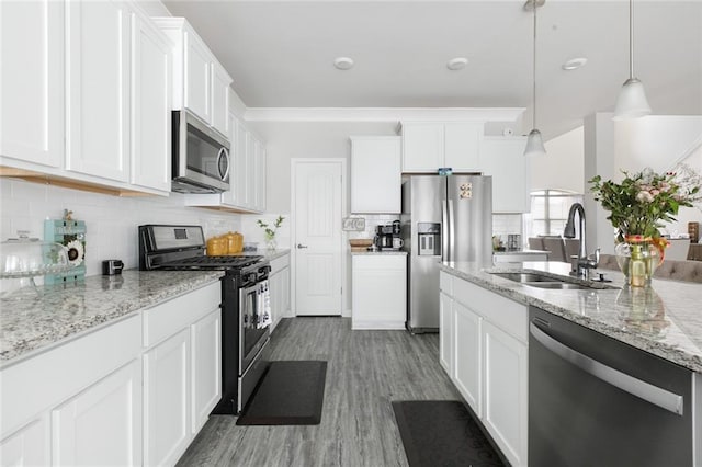 5681 Oakworth St, Slidell, LA 70461 - kitchen with stainless steel appliances, white cabinetry, backsplash, and wood finished floors