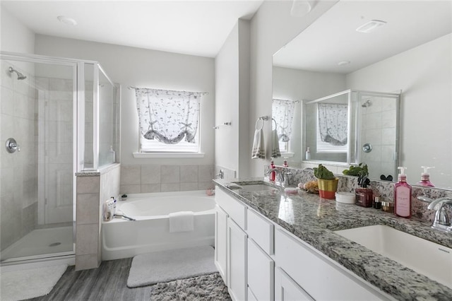 5681 Oakworth St, Slidell, LA 70461 - full bathroom featuring a stall shower, a garden tub, double vanity, and wood finished floors