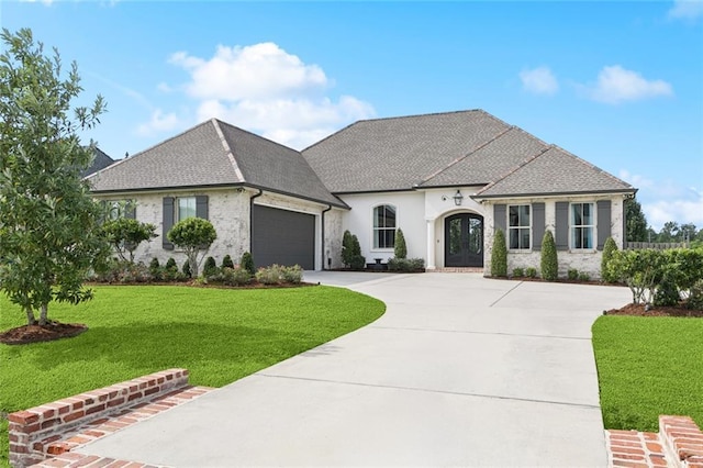130 Bald Eagle Dr, Belle Chasse, LA 70037 - french provincial home featuring french doors, driveway, an attached garage, a front yard, and stone siding