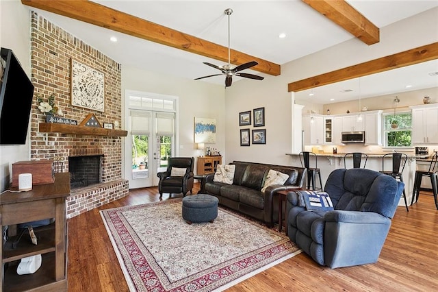 53131 S Bennett Rd, Independence, LA 70443 - living area with plenty of natural light, beam ceiling, light wood-type flooring, a ceiling fan, and a fireplace