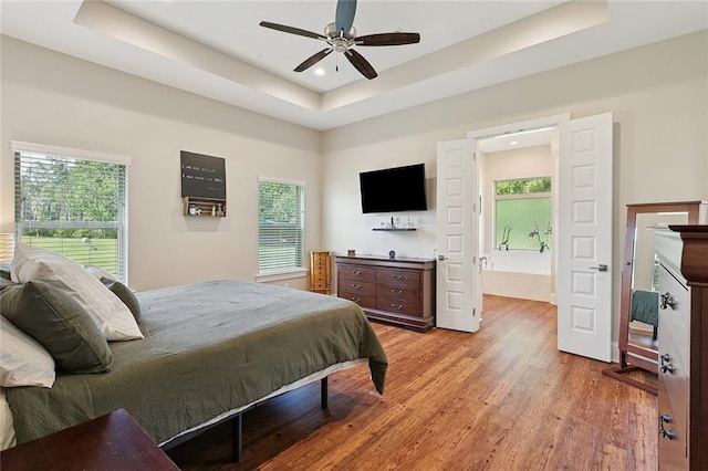 53131 S Bennett Rd, Independence, LA 70443 - bedroom featuring a tray ceiling, multiple windows, wood finished floors, recessed lighting, and connected bathroom