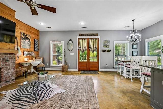 22101 Fletcher Rd, Ponchatoula, LA 70454 - living room with concrete flooring, a chandelier, a ceiling fan, recessed lighting, and an accent wall