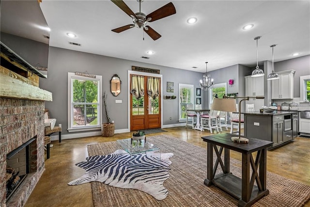 22101 Fletcher Rd, Ponchatoula, LA 70454 - living room featuring a ceiling fan, a fireplace, recessed lighting, finished concrete flooring, and a chandelier