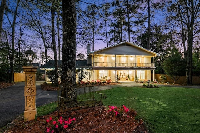 163 Tchefuncte Dr, Covington, LA 70433 - back of house at dusk featuring a balcony and a chimney