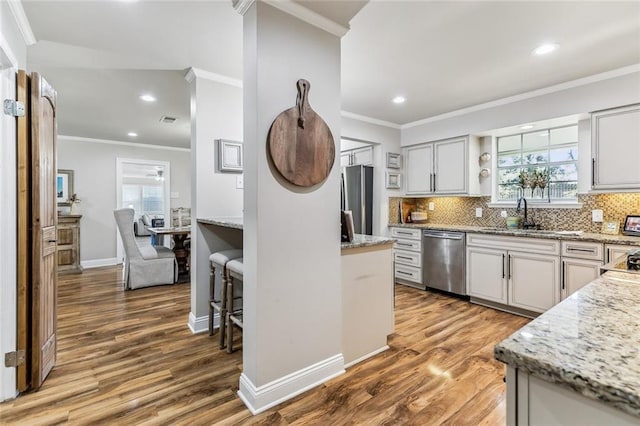 163 Tchefuncte Dr, Covington, LA 70433 - kitchen with stainless steel appliances, wood finished floors, recessed lighting, backsplash, and light stone counters