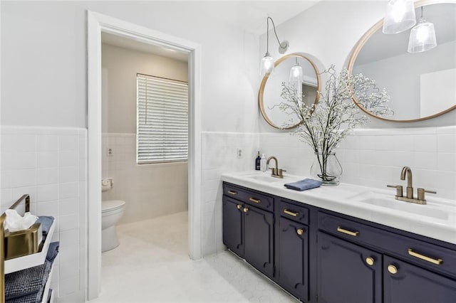 163 Tchefuncte Dr, Covington, LA 70433 - bathroom with tile walls, double vanity, and wainscoting