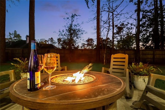 163 Tchefuncte Dr, Covington, LA 70433 - patio terrace at dusk with an outdoor fire pit and a fenced backyard