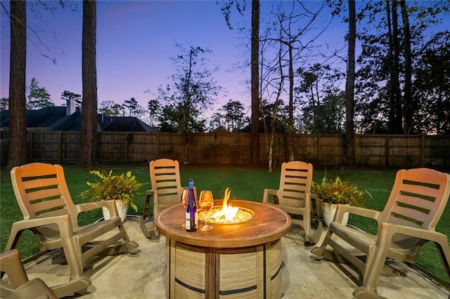 163 Tchefuncte Dr, Covington, LA 70433 - patio terrace at dusk with a fire pit, a patio, and a fenced backyard