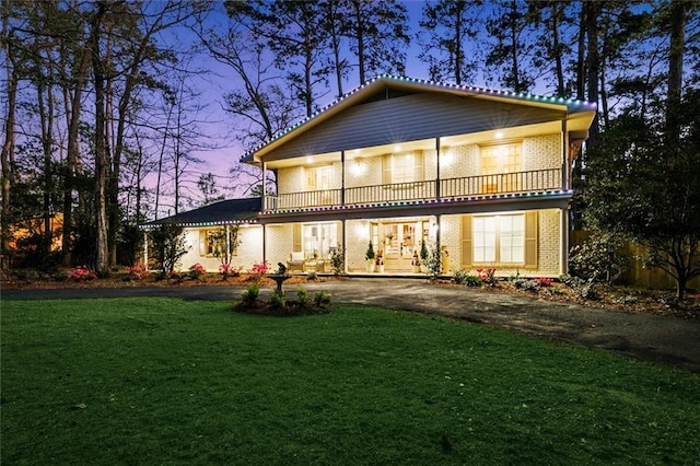 163 Tchefuncte Dr, Covington, LA 70433 - rear view of house with a balcony, brick siding, driveway, and a yard