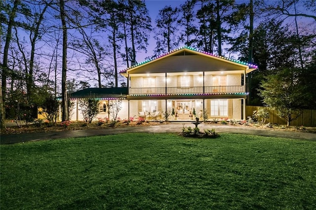 163 Tchefuncte Dr, Covington, LA 70433 - back of house at dusk featuring a balcony, asphalt driveway, and french doors