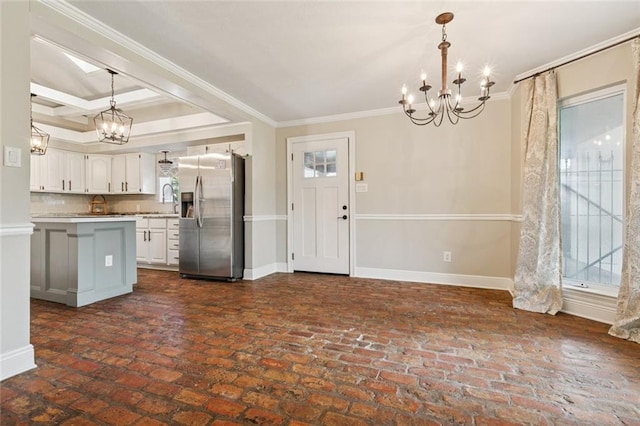 82 Melrose Dr, Destrehan, LA 70047 - kitchen with stainless steel refrigerator with ice dispenser, a chandelier, crown molding, white cabinetry, and light countertops