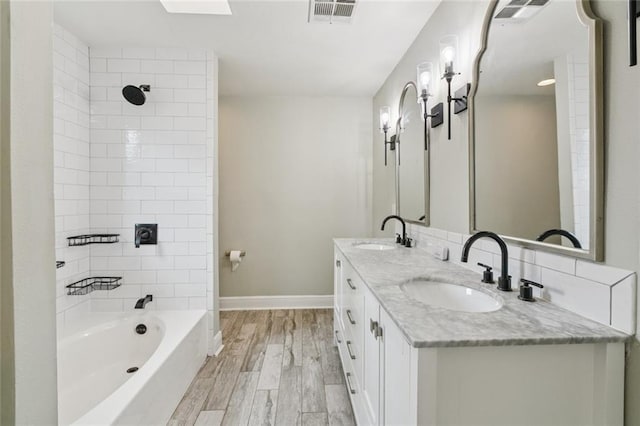 82 Melrose Dr, Destrehan, LA 70047 - full bath featuring double vanity, wood finished floors, and tub / shower combination