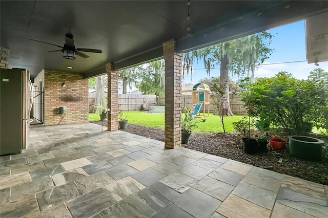 82 Melrose Dr, Destrehan, LA 70047 - fenced backyard featuring a ceiling fan, a playground, and a patio