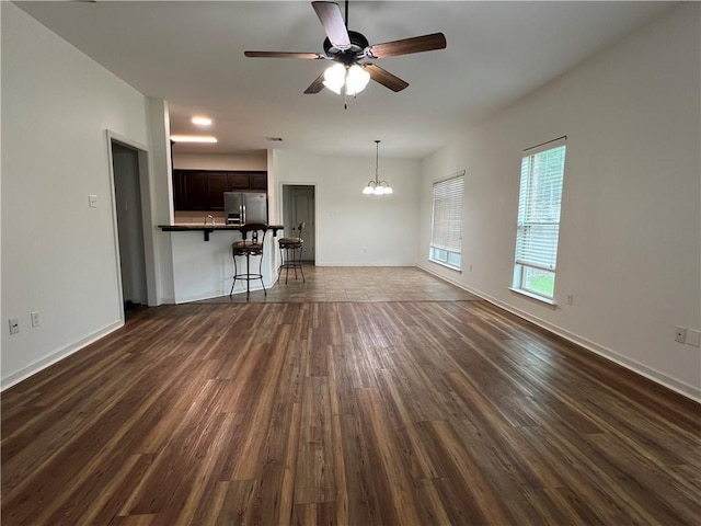 500 Buckthorne Pl, Covington, LA 70435 - unfurnished living room featuring dark wood-style flooring, a ceiling fan, and a chandelier