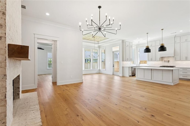 4233 Cypress Point Dr, Covington, LA 70433 - unfurnished living room with a chandelier, ornamental molding, recessed lighting, light wood-type flooring, and a brick fireplace