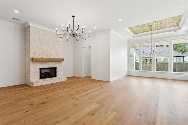4233 Cypress Point Dr, Covington, LA 70433 - unfurnished living room with a chandelier, crown molding, light wood-style flooring, a fireplace, and a tray ceiling