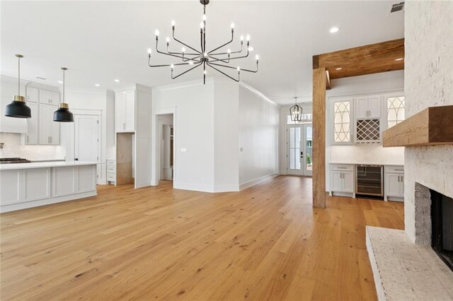 4233 Cypress Point Dr, Covington, LA 70433 - unfurnished living room with beverage cooler, a chandelier, recessed lighting, a fireplace, and crown molding