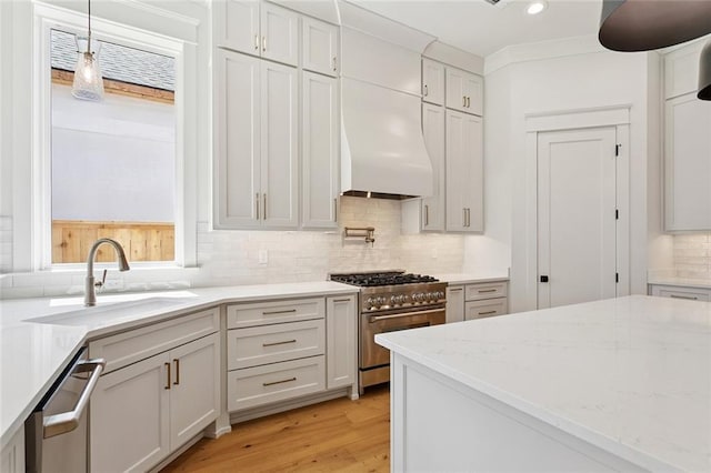 4233 Cypress Point Dr, Covington, LA 70433 - kitchen featuring appliances with stainless steel finishes, tasteful backsplash, light wood-style flooring, hanging light fixtures, and light stone counters
