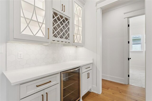 4233 Cypress Point Dr, Covington, LA 70433 - indoor dry bar with beverage cooler, light wood-style floors, and backsplash