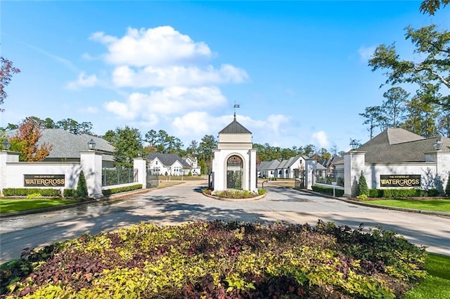 4233 Cypress Point Dr, Covington, LA 70433 - view of asphalt road with a residential view, curbs, a gated entry, and street lighting
