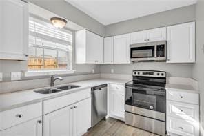 721 Heavens Dr Unit 6, Mandeville, LA 70471 - kitchen featuring stainless steel appliances, white cabinetry, light countertops, and light wood-style flooring