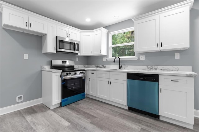 162628 Numa St, New Orleans, LA 70114 - kitchen with stainless steel appliances, light wood-style flooring, white cabinets, recessed lighting, and light stone counters