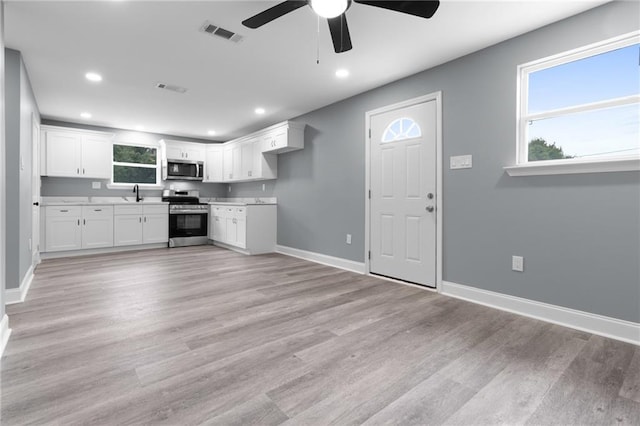 162628 Numa St, New Orleans, LA 70114 - kitchen with appliances with stainless steel finishes, a ceiling fan, recessed lighting, white cabinets, and light wood finished floors