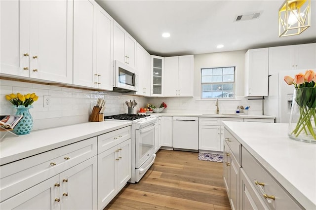143 Vans Ln, Destrehan, LA 70047 - kitchen featuring white appliances, light countertops, white cabinetry, recessed lighting, and light wood-type flooring