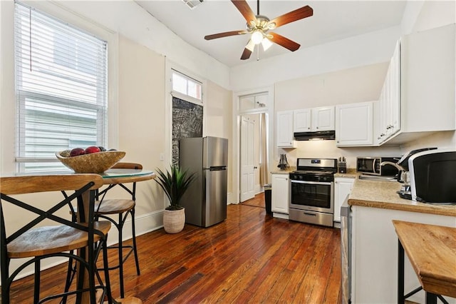 332426 Banks St, New Orleans, LA 70119 - kitchen with appliances with stainless steel finishes, under cabinet range hood, ceiling fan, light countertops, and white cabinetry