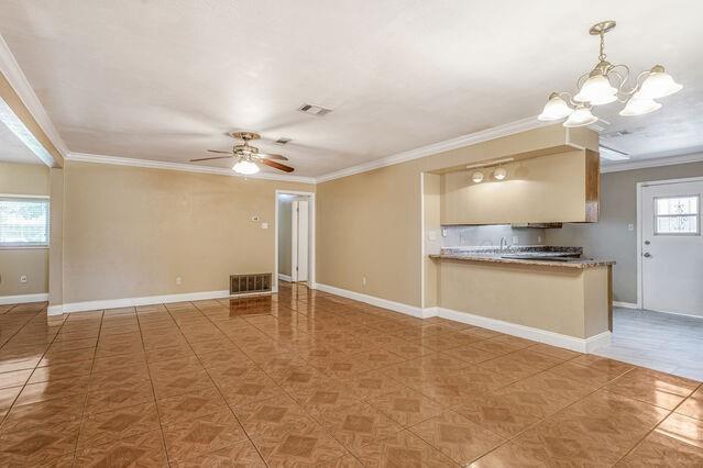 1832 Faith Pl, Gretna, LA 70056 - unfurnished living room featuring a ceiling fan, a chandelier, ornamental molding, and tile patterned floors