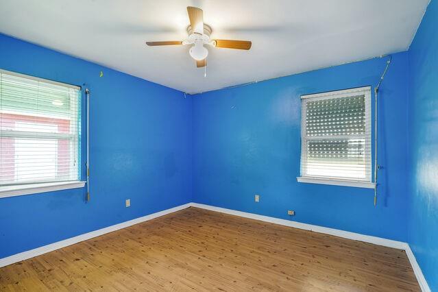 1832 Faith Pl, Gretna, LA 70056 - empty room featuring plenty of natural light, wood finished floors, and a ceiling fan