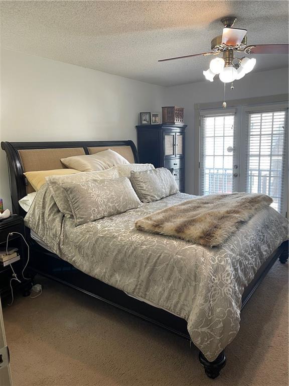 722 Marina Dr Unit 722, Slidell, LA 70458 - carpeted bedroom featuring access to outside, a textured ceiling, and ceiling fan