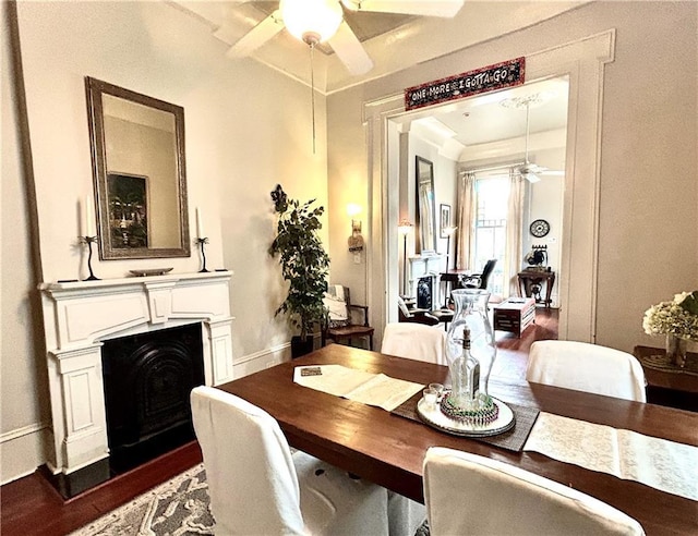 91315 Arabella St, New Orleans, LA 70115 - dining area featuring a ceiling fan, dark wood-type flooring, and a fireplace