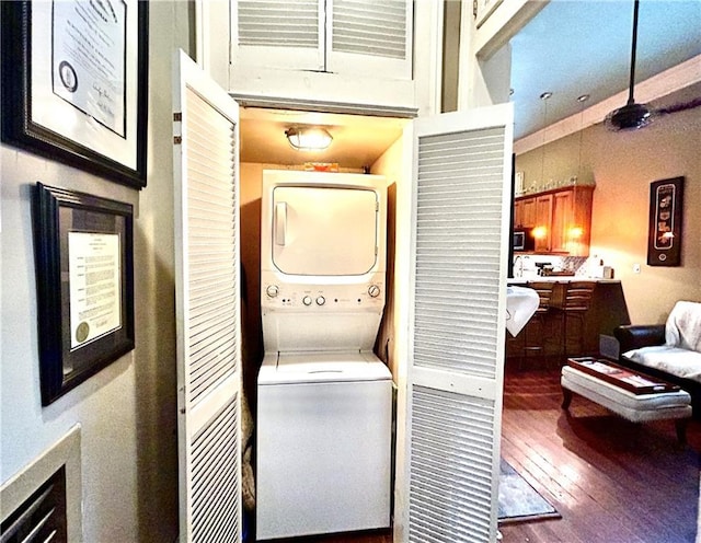 91315 Arabella St, New Orleans, LA 70115 - laundry area with stacked washer / dryer and wood finished floors