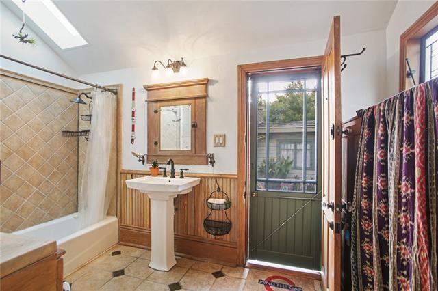 91315 Arabella St, New Orleans, LA 70115 - full bath with a skylight, tile patterned flooring, shower / bath combo, and wainscoting