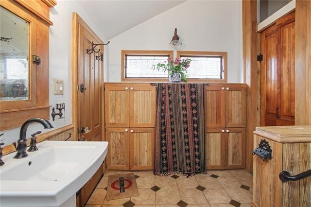 91315 Arabella St, New Orleans, LA 70115 - bathroom featuring vaulted ceiling and tile patterned flooring