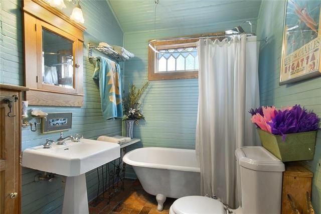 91315 Arabella St, New Orleans, LA 70115 - bathroom with a soaking tub and wooden walls