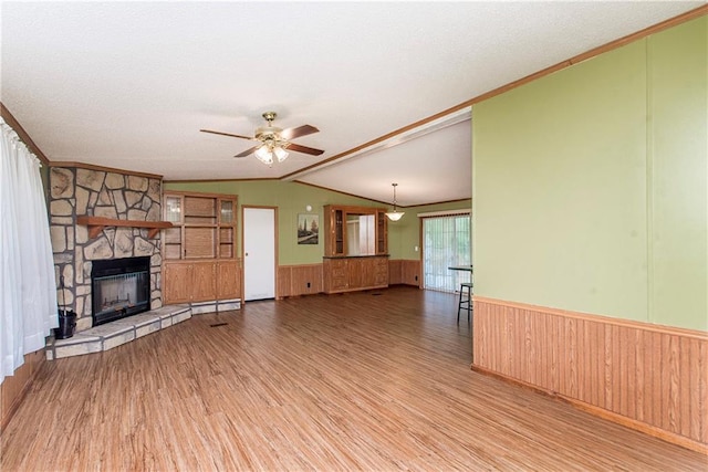 25169 Stepp Rd, Robert, LA 70455 - unfurnished living room featuring wainscoting, lofted ceiling, wood finished floors, a ceiling fan, and crown molding