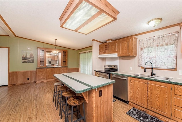25169 Stepp Rd, Robert, LA 70455 - kitchen featuring appliances with stainless steel finishes, ornamental molding, under cabinet range hood, vaulted ceiling, and light wood-style flooring