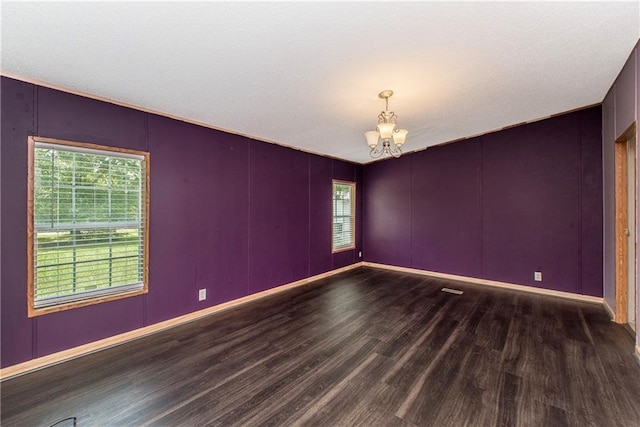 25169 Stepp Rd, Robert, LA 70455 - unfurnished room with wood finished floors, a chandelier, and a decorative wall