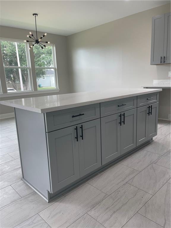 680 Hunterbrook Dr, Gretna, LA 70056 - kitchen featuring gray cabinetry, light countertops, a chandelier, and pendant lighting