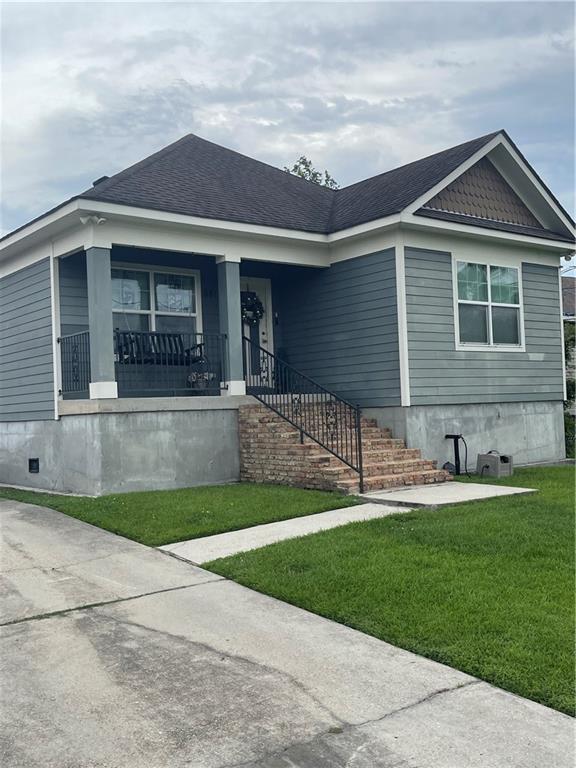 5817 Providence Pl, New Orleans, LA 70126 - view of front of property featuring a front yard, covered porch, and crawl space