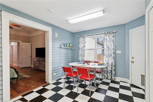 1906 Audubon St, New Orleans, LA 70118 - dining area featuring tile patterned floors, wooden walls, and a ceiling fan