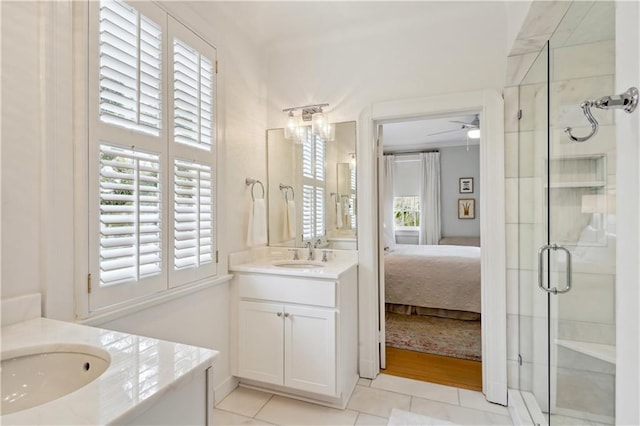 450 Fairway Dr, New Orleans, LA 70124 - full bathroom with two vanities, a shower stall, tile patterned floors, connected bathroom, and ceiling fan