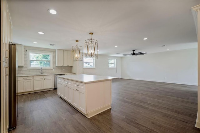 5613 Morton St, Metairie, LA 70003 - kitchen with dark wood finished floors, recessed lighting, tasteful backsplash, white cabinets, and appliances with stainless steel finishes