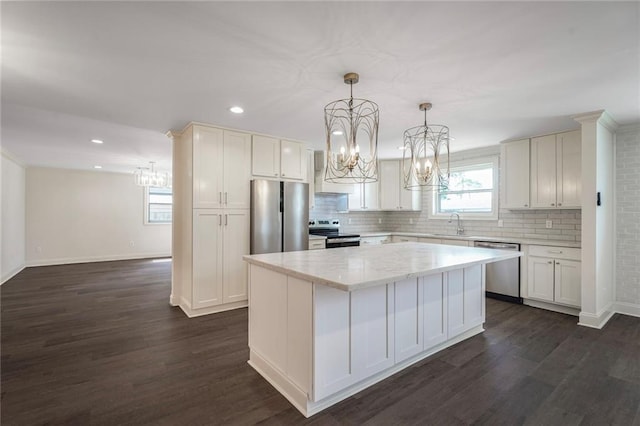 5613 Morton St, Metairie, LA 70003 - kitchen with stainless steel appliances, a chandelier, a kitchen island, dark wood finished floors, and recessed lighting