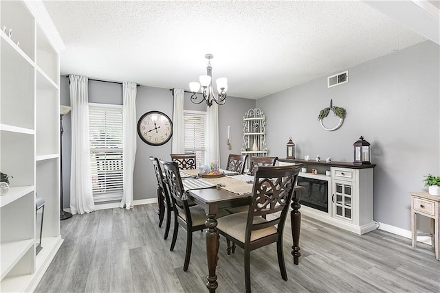 1927 Wyndemere Dr, Slidell, LA 70461 - dining room featuring wood finished floors, a chandelier, and a textured ceiling