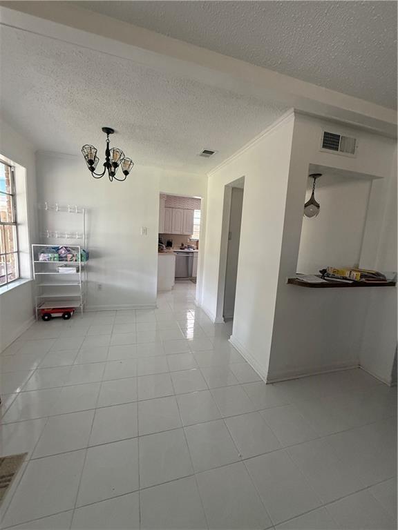 3757 Mimosa Ct, New Orleans, LA 70131 - hall with a chandelier, a textured ceiling, and light tile patterned floors