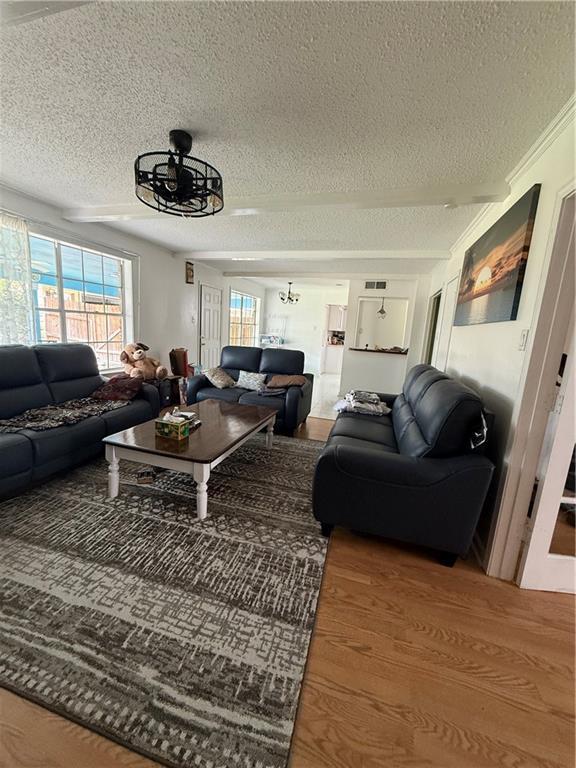 3757 Mimosa Ct, New Orleans, LA 70131 - living area with a textured ceiling, a chandelier, and wood finished floors
